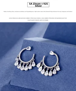 Detail of C-shaped 925 silver earrings featuring water-drop 5A zircon stones on blue cubes