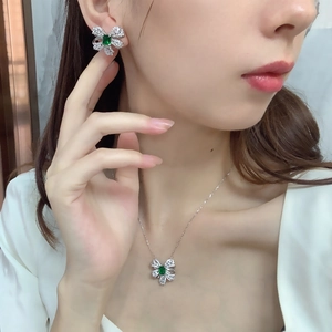 Close-up of S925 silver emerald bow necklace and earrings set worn by a model