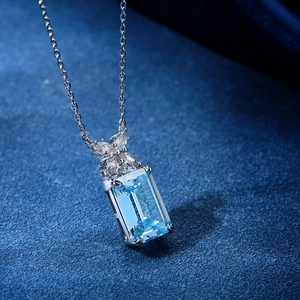 Aquamarine necklace with emerald-cut blue gemstone and marquise diamond flower pendant