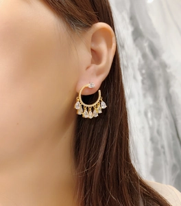 Detail of s925 silver hoop earrings with pavé setting and sparkling teardrop zircon pendants