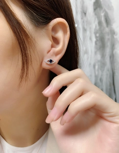 Detailed view of S925 sterling silver evil eye stud earring with blue stone and zircons