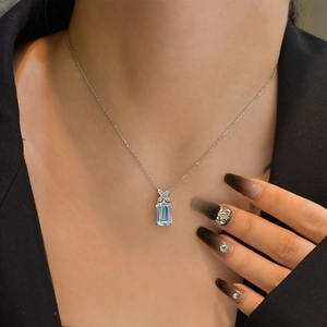 Elegant rectangular aquamarine pendant necklace with silver chain on model's neckline