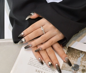 Macro detail of a vine-lace silver ring with carbon diamonds worn on a finger