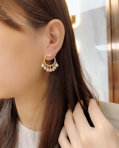 Close-up of golden teardrop chandelier earrings with sparkling cubic zirconia on model