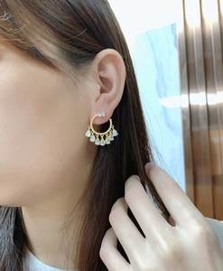 Close-up of fan-shaped fringe earrings with pear-cut cubic zirconia on model ear