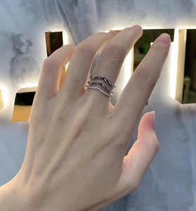 Detailed view of 925 sterling silver layered V-shaped wave ring with pave crystals