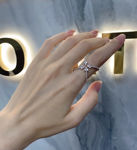 Close-up of silver-tone cross ring with starburst design and pavé cubic zirconia