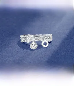 Detailed view of silver triple-layer chain ring with heart and zircon charms