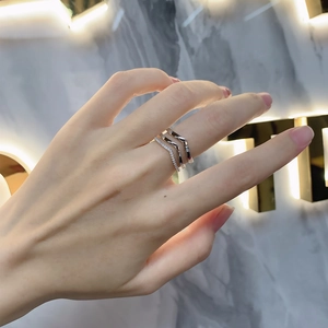 Detailed close-up of three-piece V-shaped stacked 925 sterling silver rings on a finger