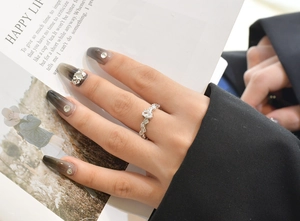 Macro detail of silver vine ring with oval carbon diamond on model's finger