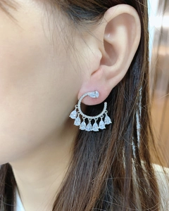 Detail of silver drop earrings with fanned teardrop zircons on a model's ear