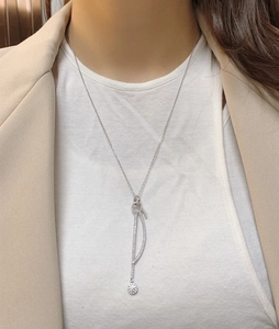 Vue détaillée du collier en Y argenté avec courbes en pavé de diamants et pendentif rond