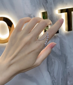 Detailed view of asymmetric 925 silver ring with sparkling white gemstones on finger