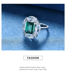 Macro detail of emerald-cut green gemstone crown ring with sparkling marquise accents