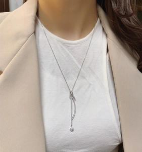 Détail d'un collier en argent S925 avec pendentif incurvé et sphère sertie de zircons