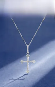 Macro detail of S925 silver cross pendant with 5A cubic zirconia on textured background