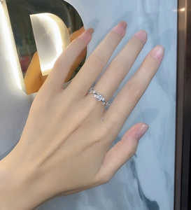 Detailed view of vine-shaped silver ring with oval stone and diamonds on a finger