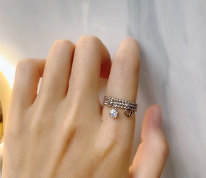 Detail of s925 silver triple-layered ring with star, zircon, and circle charms