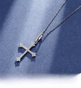 Detailed view of S925 silver cross pendant with micro-pave white zircons on blue fabric