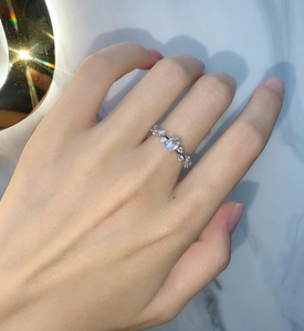 Macro detail of silver ring featuring oval main stone and vine-style diamond settings