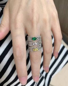 Detalle de anillos S925 apilados con piedras preciosas ovales esmeralda, amarillas y claras