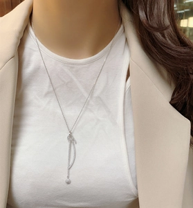 Détail macro d'un collier pendentif à pompon en argent sterling 925 sur un mannequin