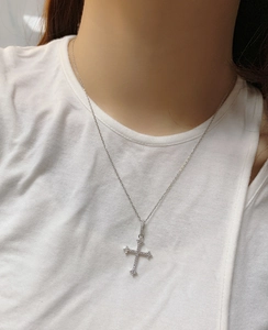 Detailed view of S925 silver cross necklace with pavé zircons on model neckline