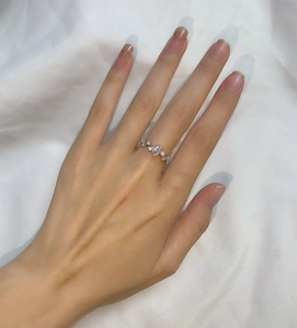 Detailed macro shot of a silver vine band ring with an oval diamond on a model's finger