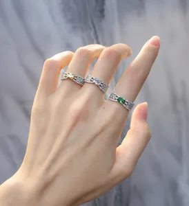 Detailed view of three-piece S925 silver rings with emerald and zircon stones on hand