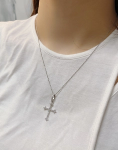 Close-up of S925 sterling silver cross necklace with sparkling cubic zirconia on neck