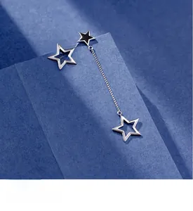 Detail of asymmetric S925 silver star earrings featuring a long tassel chain and matte finish