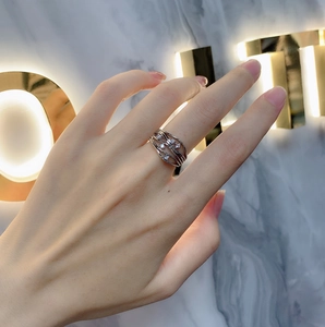 Macro detail of silver S925 multi-layer wavy ring with zircon stones on a model's finger
