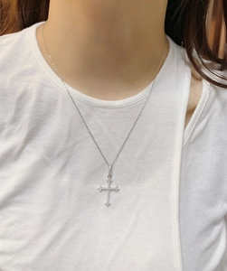 Close-up of S925 sterling silver cross necklace with sparkling cubic zirconia on model