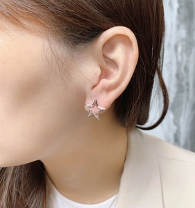 Close-up of minimalist hollow star silver stud earring worn by a model