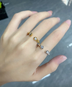 Detail of adjustable twisted silver and gold rings featuring zircon stones on hand