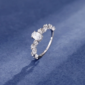 Silver vine band ring featuring a large oval solitaire diamond with side stone accents