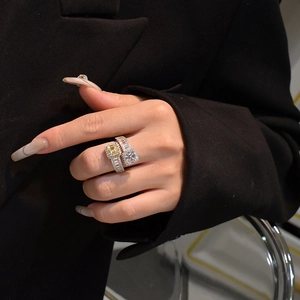 Detail of Toi et Moi silver ring with yellow and clear Asscher cut stones on finger