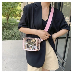 Detail of pink PVC jelly bag with wide canvas strap and elegant decorative silk scarf inside