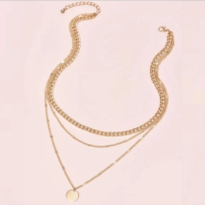 Three-layer gold chain necklace with bold curb chain and polished round disk pendant
