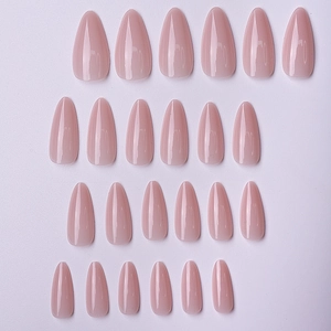 Close-up detail of glossy almond-shaped press-on nails in a soft nude pink finish.
