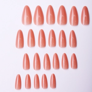 Detailed view of premium glossy apricot solid color long almond-shaped press-on nails set.