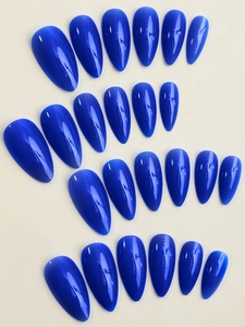 Detailed view of glossy deep blue almond-shaped long press-on nails on beige background