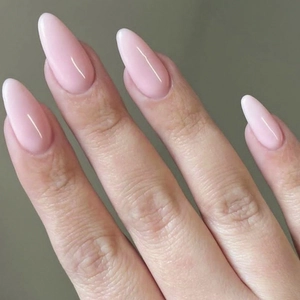 Close-up view of elegant long almond-shaped glossy light pink press-on nails on hand