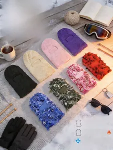 Winter balaclava collection in various colors displayed on snowy outdoor wooden deck