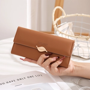 Gros plan sur un long portefeuille en cuir avec une boucle feuille en métal et pression