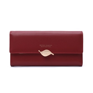 Détail du portefeuille long bordeaux avec fermoir feuille dorée et cuir mat élégant