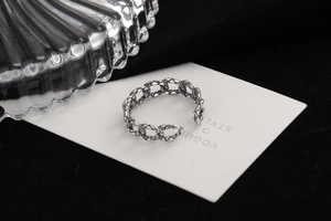 Detail of vintage silver chain ring with adjustable opening on black velvet background