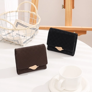 Detail of dark brown and black bi-fold wallets featuring golden leaf metal clasps