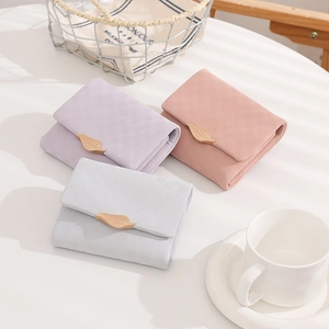 Detail of leaf buckle on pastel PU leather wallets in purple, pink and gray