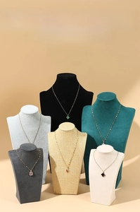 Detail of elegant velvet and linen mannequin bust displays for luxury necklace presentation